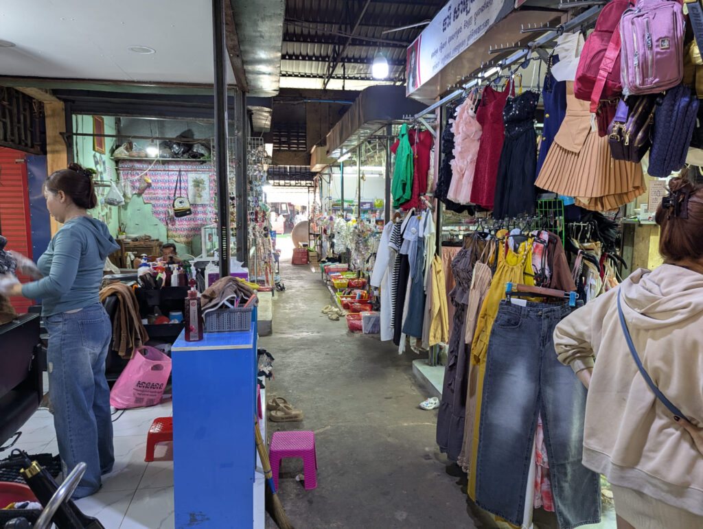 Marktstand mit Kleidung und ein Damen-Friseur