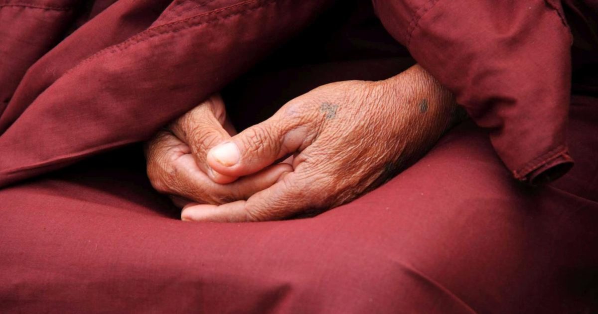 Ein buddhistischer Mönch in dunkelroter Robe.