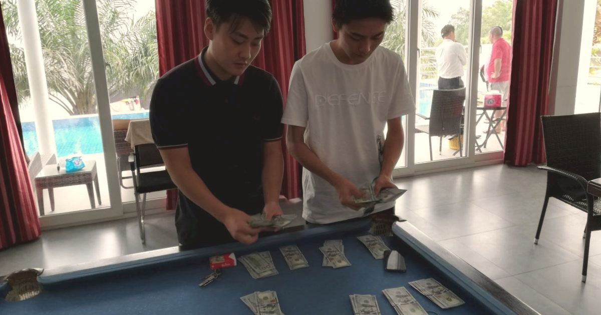 Zwei Chinesen zählen Dollarnoten.