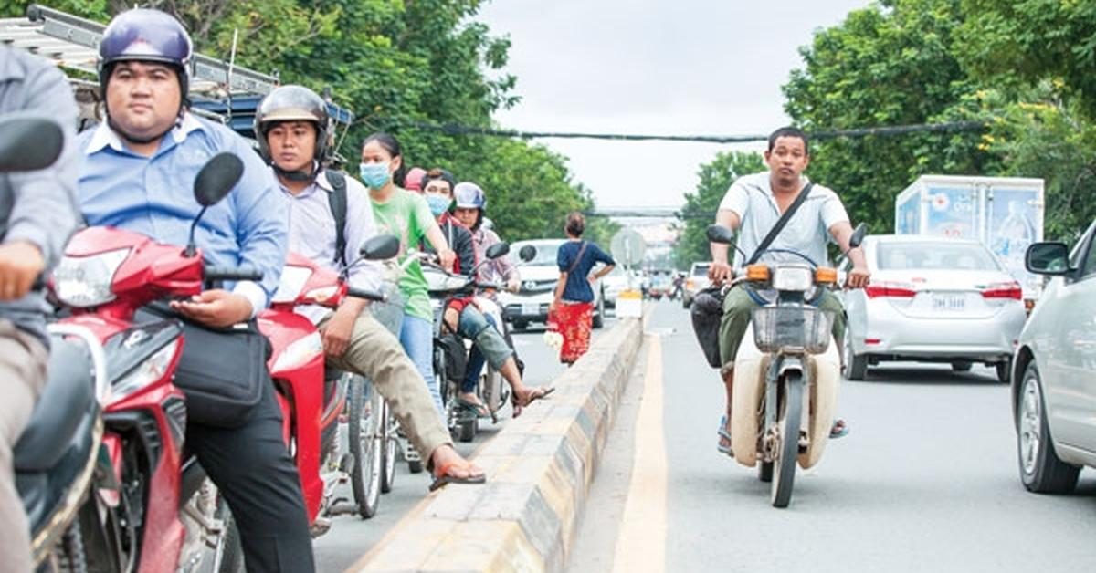 Motorradfahrer warten an einer roten Ampel in Phnom Penh.